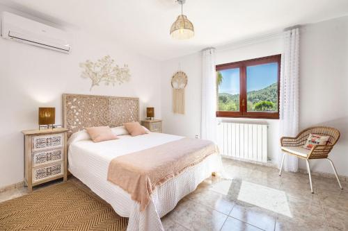 a bedroom with a bed and a chair and a window at Can Prats Country House in Sant Josep de Sa Talaia