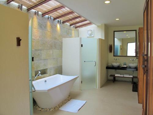 a bathroom with a bath tub and two sinks at Bluewater Sumilon Island Resort in Sumilon Island