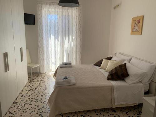 ein Schlafzimmer mit einem großen Bett und einem Fenster in der Unterkunft Casa Livia in Castellabate