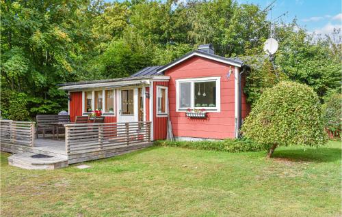 a red tiny house in a yard at Gorgeous Home In Fjälkinge With Wifi in Fjälkinge