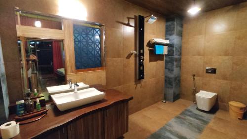 ein Bad mit einem Waschbecken und einem WC in der Unterkunft Shivaaz Holiday Farms - Near Mopa Airport Goa in Dodamarg