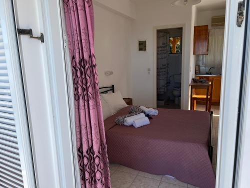a bedroom with a bed with pink curtains at Alexandra’s Studios Sunset View in Argostoli