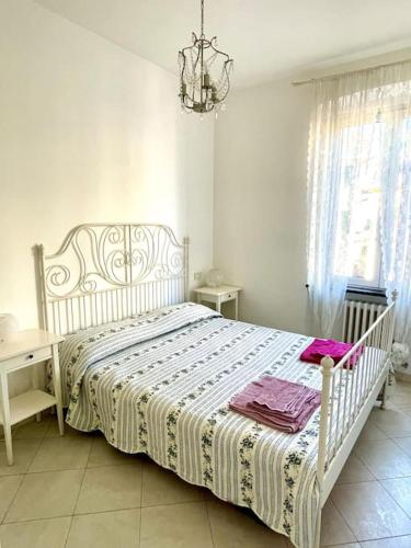 - un lit blanc dans une chambre dotée d'un lustre dans l'établissement Splendido trilocale a due passi dal mare, à Santa Margherita Ligure