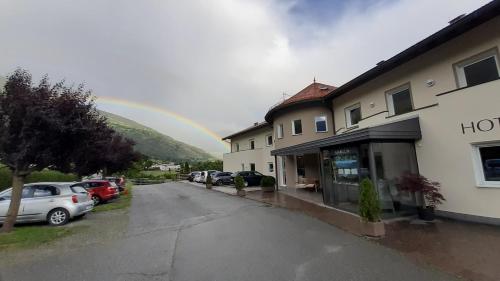 a rainbow over a parking lot next to a building at Margun - Apartments & PanoramaRooms in Malles Venosta