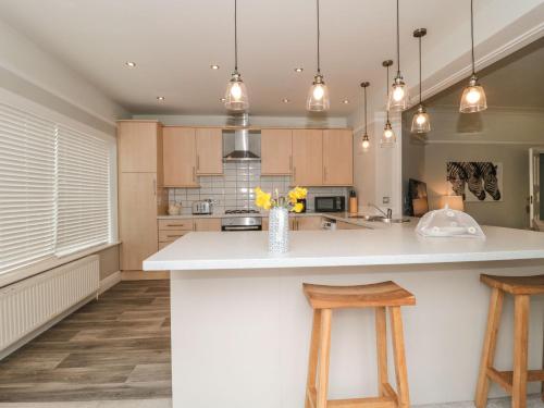 a kitchen with a large white island with two stools at The Anchorage in Bournemouth
