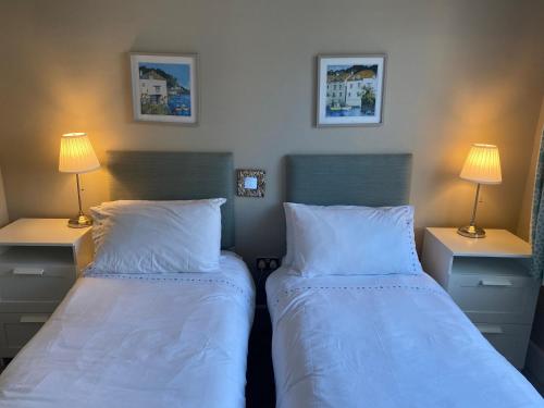 two beds in a small room with two lamps at The Anchorage in Bournemouth
