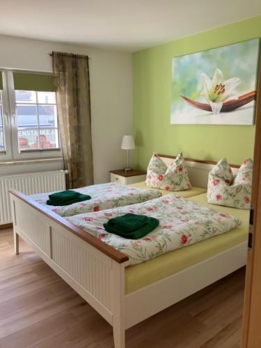 um quarto com uma cama grande com lençóis e almofadas verdes em Ferienwohnung Claus em Meissen
