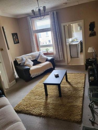 a living room with a couch and a table at Spacious 2-Level Home by the Beach & Transport in Methil