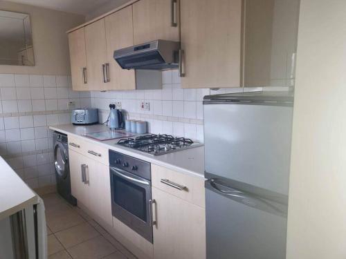 a kitchen with a stove and a refrigerator at Homely Apartment near the Beach with Mini Luxuries in Methil