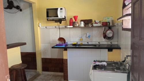 una pequeña cocina con fregadero y microondas en Casa do Murebe en Búzios