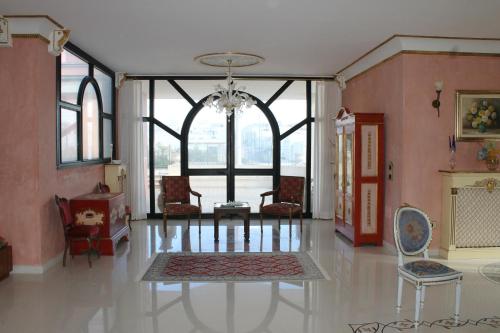 un salon avec un lustre et une grande fenêtre dans l'établissement Villa la Bifora by Salento com, à Castrignano del Capo