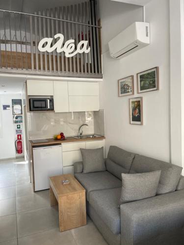 a living room with a couch and a kitchen at Alfa Studio in Kavála
