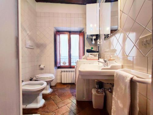 een witte badkamer met een toilet en een wastafel bij Convento San Gimignano Apartments in San Gimignano