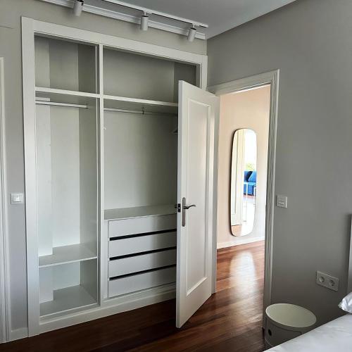 a bedroom with a closet with glass doors at CASA AZUL SANTA KATALINA in Mundaka