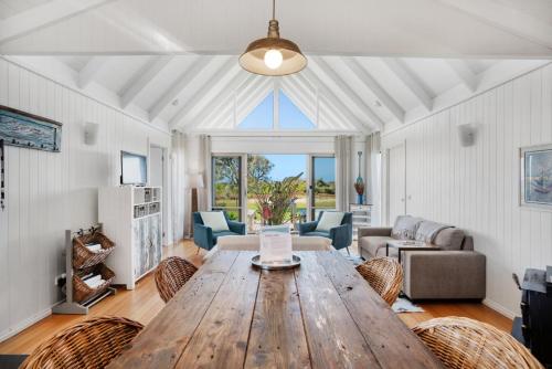 a living room with a wooden table and chairs at Bear Gully Coastal Cottages in Walkerville