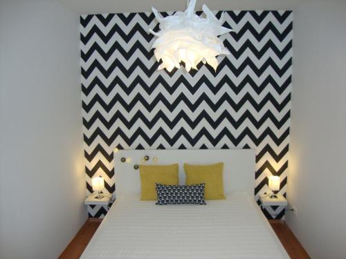 een slaapkamer met een bed met een geruite muur bij Viktória Beach Apartman Gold 1. Siófok in Siófok