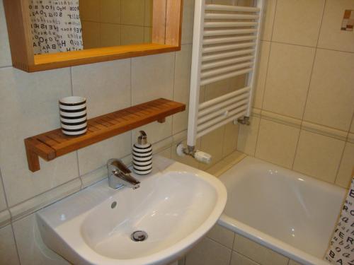 y baño con lavabo y bañera. en Viktória Beach Apartman Gold 1. Siófok, en Siófok