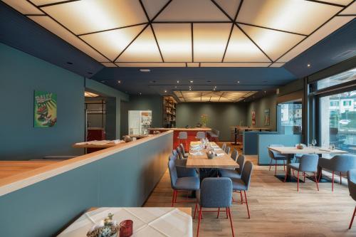 a restaurant with tables and chairs and a bar at b-smart hotel Schönenwerd in Aarau