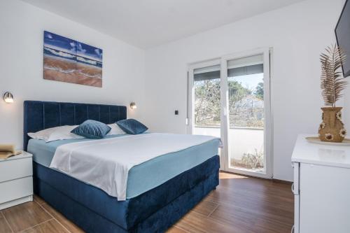 a bedroom with a blue bed and a window at Villa Tomic in Vir
