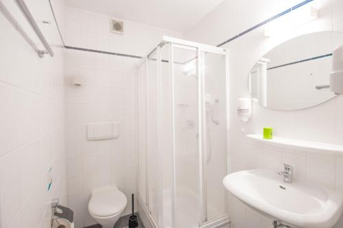 bagno bianco con doccia e lavandino di Hotel garni Zwickau-Mosel a Mülsen