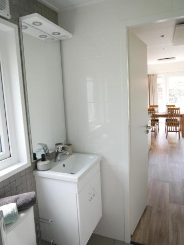 a white bathroom with a sink and a dining room at Tiny Ferienhaus Kelze in Hofgeismar