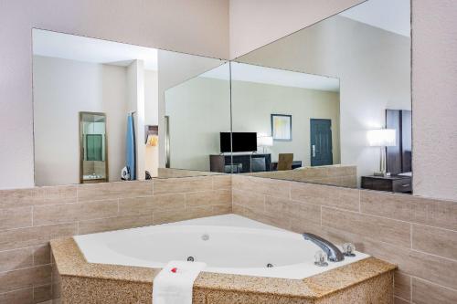 un ampio bagno con vasca e grande specchio di Baymont by Wyndham Midway Tallahassee a Midway