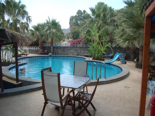 a table and chairs in front of a swimming pool at Hotel Al Togo Fitness & Relax in Vulcano