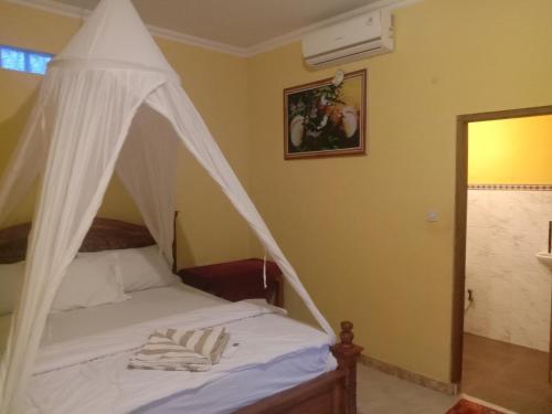 sypialnia z łóżkiem z białym baldachimem w obiekcie Khailash Warung and Home Stay w mieście Sidemen