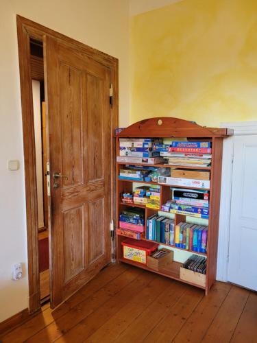 a book shelf filled with books next to a door at Haus Schmeile in Magdeburg