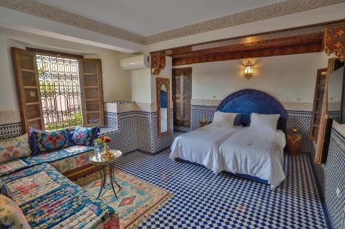 a bedroom with a large bed and a couch at Riad Semlalia in Fez