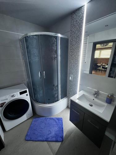 a bathroom with a shower and a sink and a microwave at Apartament VIP-2 in Reda