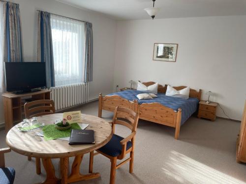 a small room with a bed and a table with a table at Landgasthof und Landpension Hohenkirchen in Hohenkirchen