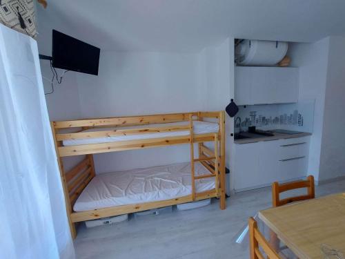 Cette chambre dispose de lits superposés, d'une télévision et d'un bureau. dans l'établissement Studio cosy à 80m de la plage avec jardin et jeux pour enfants - FR-1-423-238, au Grau-dʼAgde