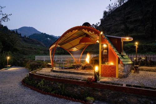 a small building with lights on it on a road at Zostel Plus Mussoorie- Kempty in Mussoorie