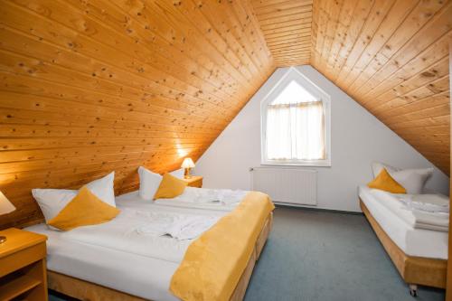 2 camas en una habitación con techo de madera en Hotel garni Zwickau-Mosel, en Mülsen