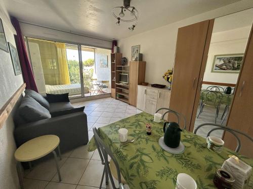 un salon avec une table et un canapé dans l'établissement Studio climatisé avec piscine et parking - 4 couchages - Port Camargue - FR-1-250-194, au Grau-du-Roi