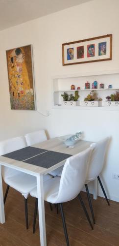 Cà Comare Burano في بورانو: غرفة طعام مع طاولة بيضاء وكراسي بيضاء