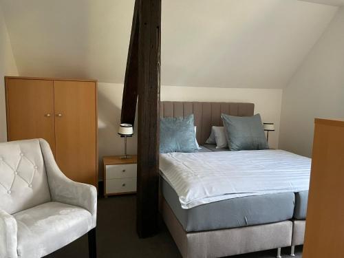 a bedroom with a bed and a chair at Ferienwohnung Brunnenhaus in Bad Sassendorf
