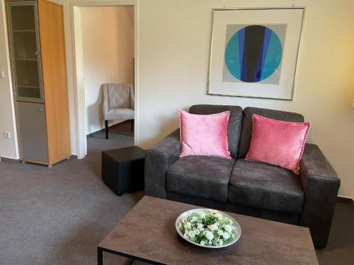 a living room with a brown couch and pink pillows at Ferienwohnung Brunnenhaus in Bad Sassendorf