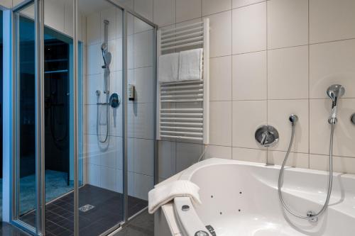 uma casa de banho com um chuveiro e uma banheira em b-smart hotel Schönenwerd em Aarau
