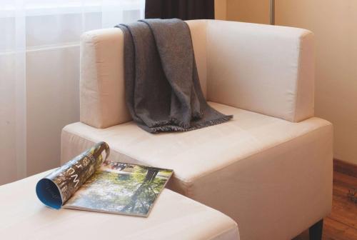 a book sitting on top of a couch with a blanket at Vienna House by Wyndham Thüringer Hof Eisenach in Eisenach