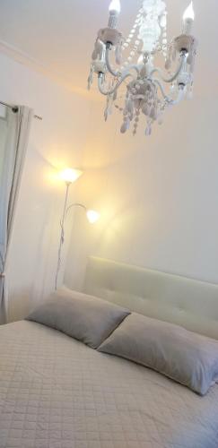 a bedroom with a bed and a chandelier at Burano Cà Comare in Burano