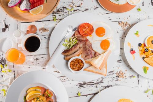 een tafel met borden ontbijt erop bij Bay Beach Resort in Choeng Mon Beach