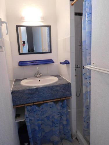une salle de bain avec un lavabo et un miroir dans l'établissement OREE DU GOLF II Joli T3 piscine proche golf Cap d'Agde, au Cap d'Agde