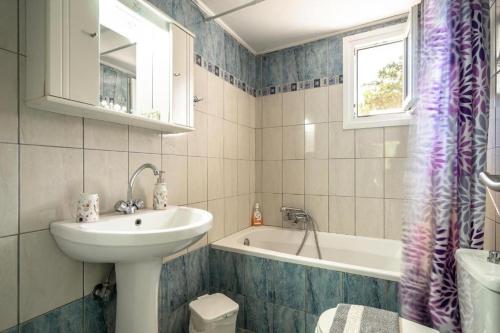 ein Badezimmer mit einem Waschbecken und einer Badewanne in der Unterkunft Mary's house in Argostoli