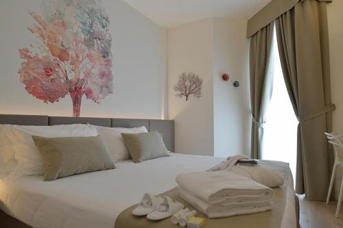 una camera da letto con un letto con asciugamani e scarpe di Hotel Elite a Lido di Jesolo