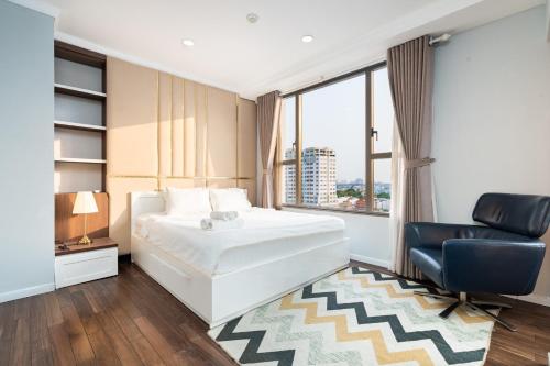 een slaapkamer met een bed, een stoel en een raam bij 2BRs City View in the HEART of SAIGON - Free Infinity Pool in Ho Chi Minh-stad