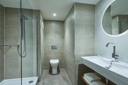 a bathroom with a toilet and a sink and a shower at Manchester Marriott Victoria & Albert Hotel in Manchester