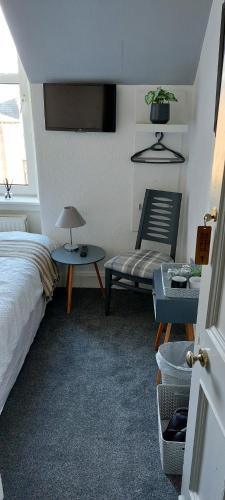 インバネスにあるRiverbank Guesthouse Invernessのベッドルーム1室(ベッド1台、椅子、テーブル付)