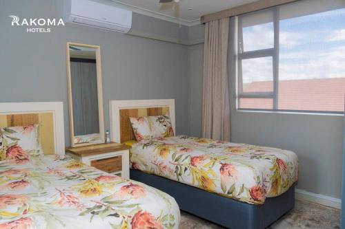 a bedroom with two beds and a window at Deluxe 3 Bed Apartment in Polokwane